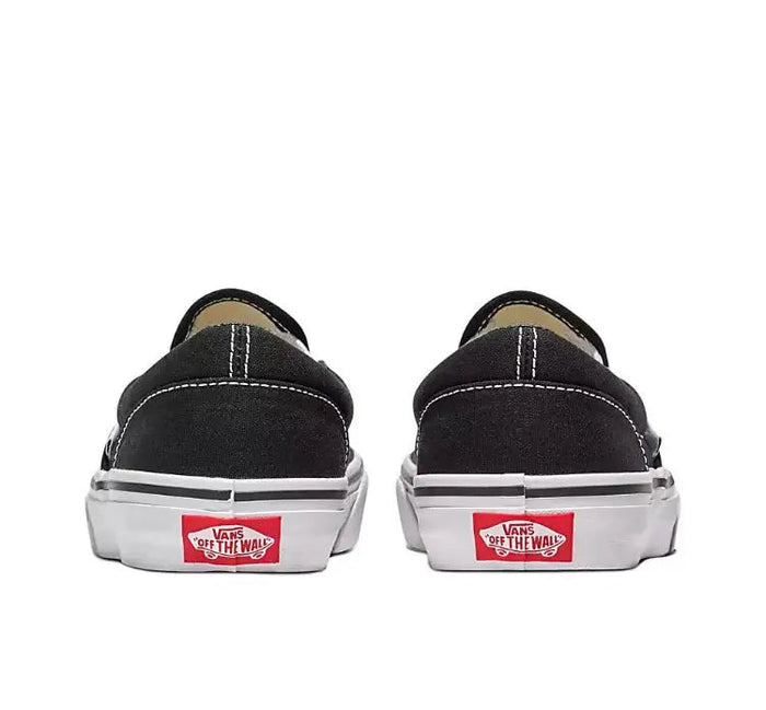 Vans Slip On black canvas sneakers with Vans heel label and white rubber sidewalls, back view.