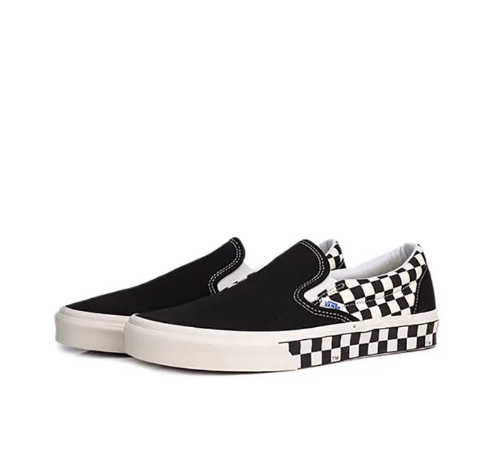 Vans slip-on sneaker, black canvas with checkered detail and white midsole