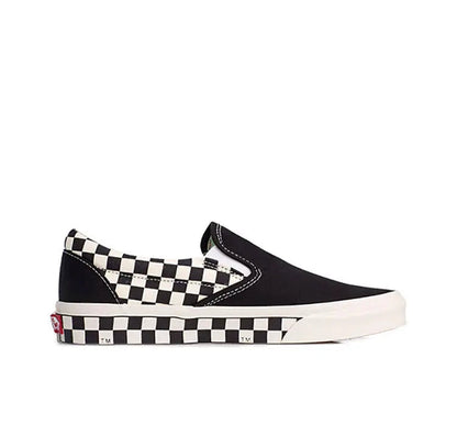 Vans slip-on sneaker side view, black canvas with checkered strap and white outsole