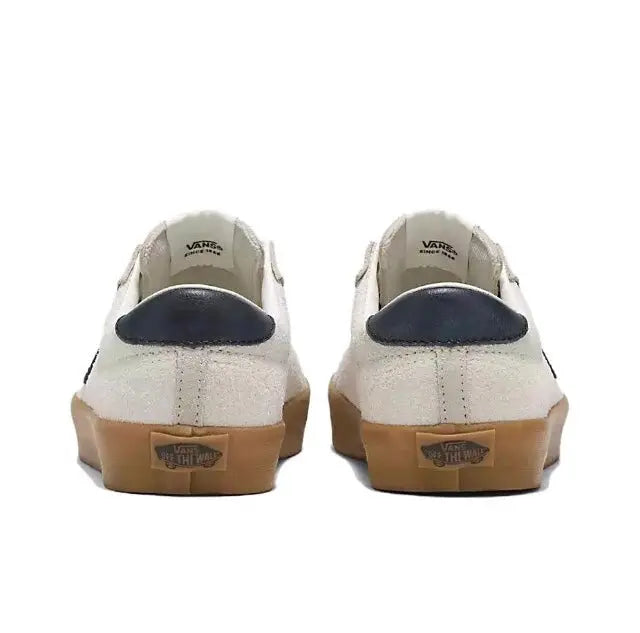 Vans low-top sneakers back view with beige/white uppers, navy heel detail, gum outsole