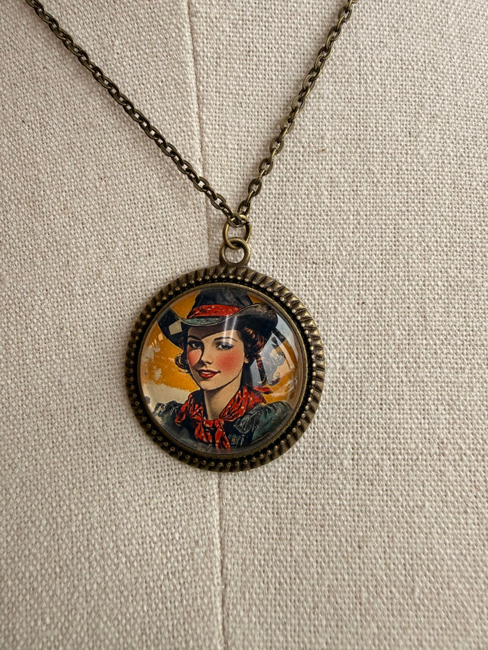 Round cowgirl portrait glass pendant with ornate bezel on dark chain