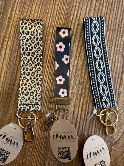 Set of three patterned wristlet key chains with gold keyrings and round QR tags