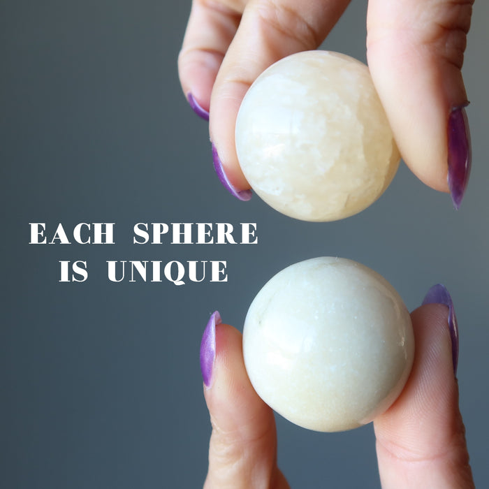hands holding yellow aventurine spheres to show each is unique