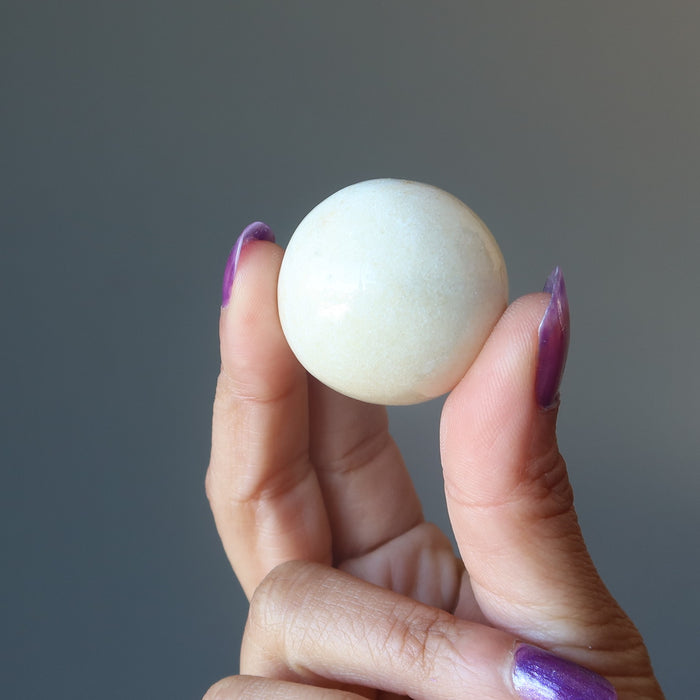 hand holding yellow aventurine sphere