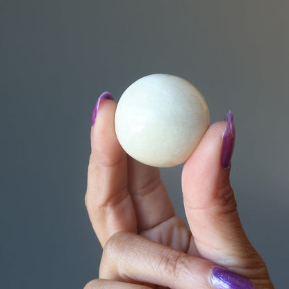 hand holding yellow aventurine sphere