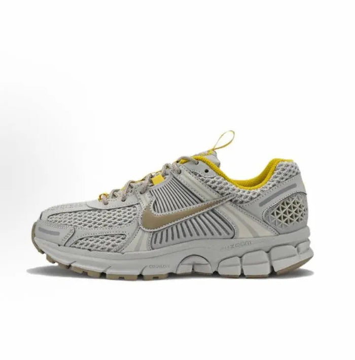 Light gray running sneaker with yellow lining, lace-up front, and Nike swoosh