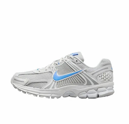 Running shoes in white with blue swoosh, mesh upper, lace-up design, gray overlays
