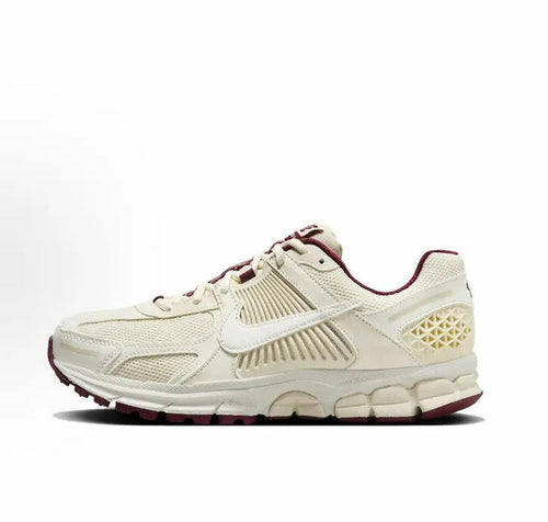White Nike running sneaker with burgundy accents and cushioned sole