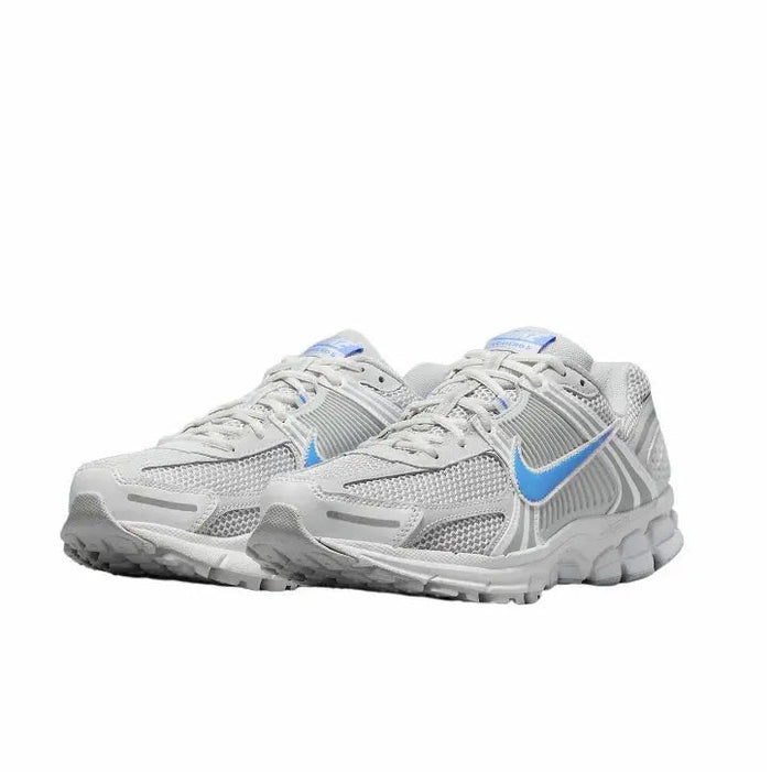 Running shoes side view: white knit mesh with blue accents and gray textured panels