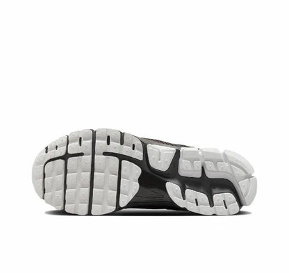 Running shoe sole view with white cushioning pods and dark tread