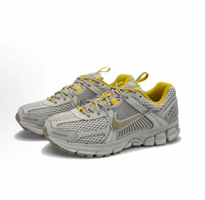 Light gray running sneaker pair with yellow collar, lace-up front, and Nike swoosh