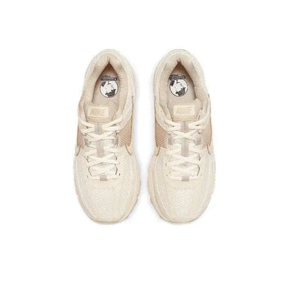 Pale ivory lace-up running sneakers with cushioned tongues and Nike logos