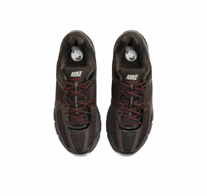 Pair of lace-up running shoes, dark upper with red laces and Nike logo