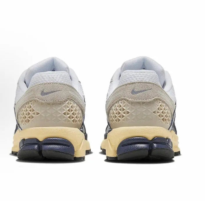 Nike running sneaker heels in light gray with tan textured heel panel and navy strap