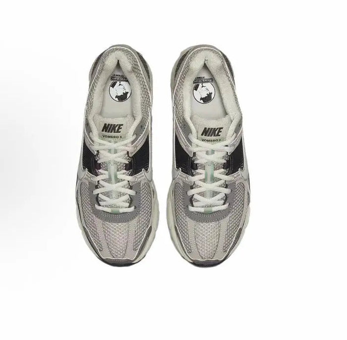 Running sneaker pair, light gray mesh uppers with white laces and Nike logo branding