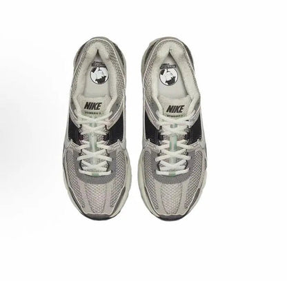 Running sneaker pair, light gray mesh uppers with white laces and Nike logo branding