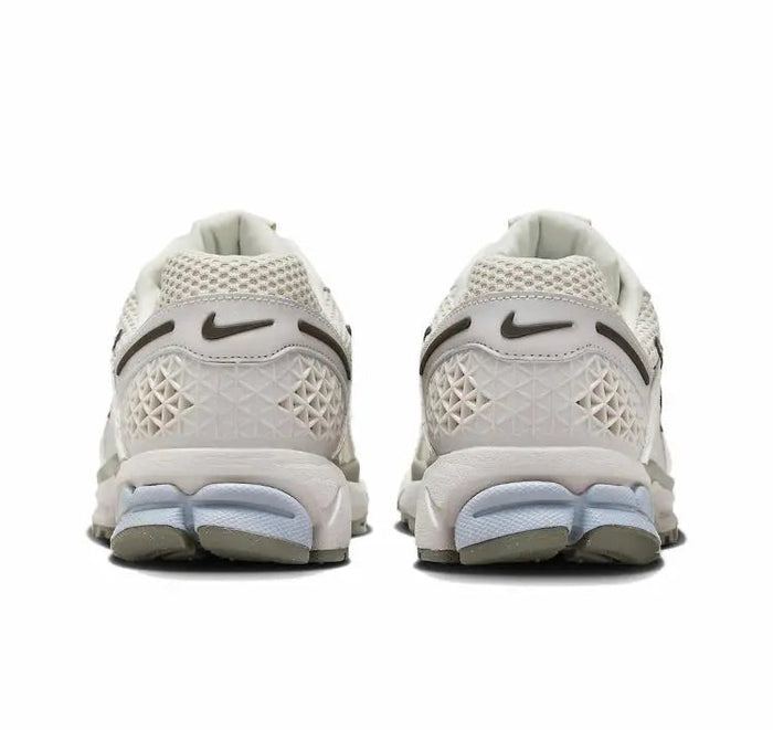 Nike Zoom Vomero 5 SP running shoe back view, light beige knit with blue midsole
