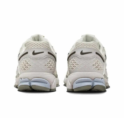 Nike Zoom Vomero 5 SP running shoe back view, light beige knit with blue midsole