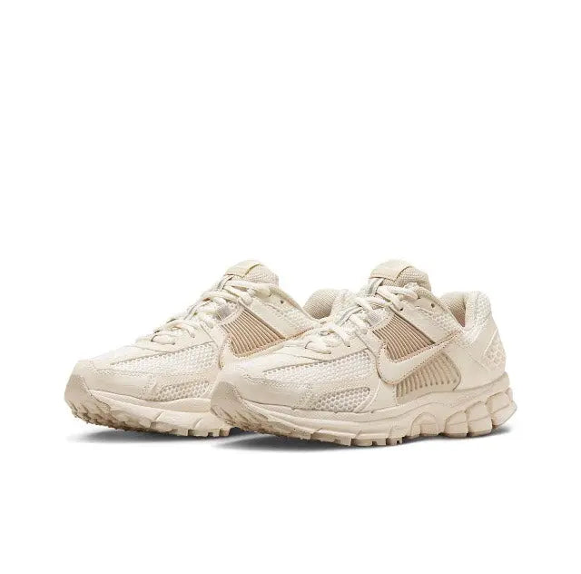 Pale ivory running sneakers with ribbed cage overlays and padded collar