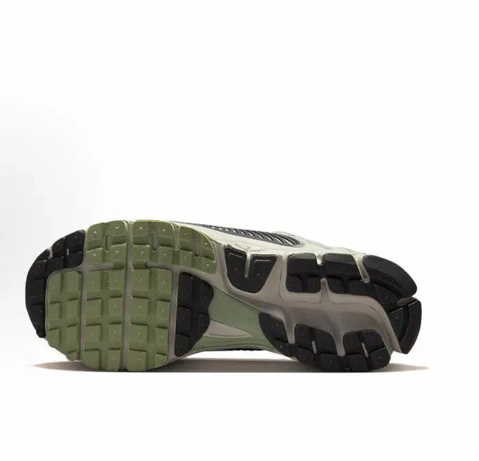 Running shoe outsole, dark traction pods on black tread with light gray sidewalls