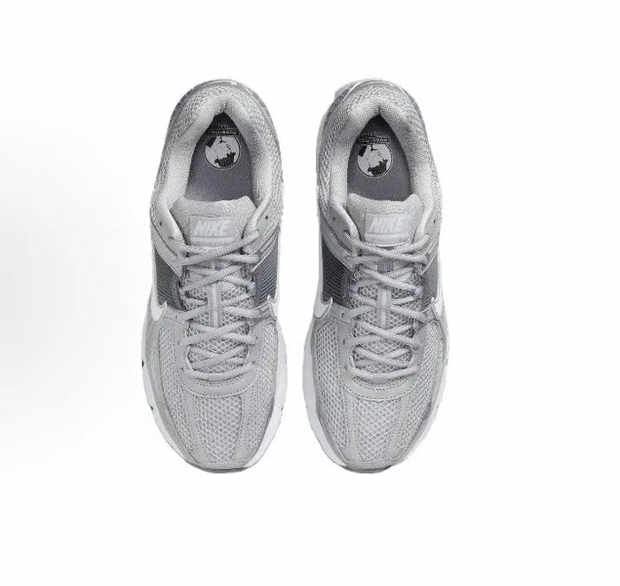 Running shoe, light grey knitted upper with laces and Nike logo at tongue