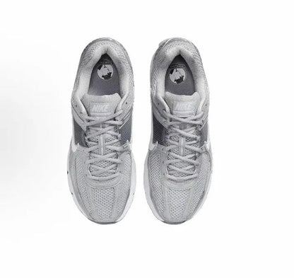 Running shoe, light grey knitted upper with laces and Nike logo at tongue