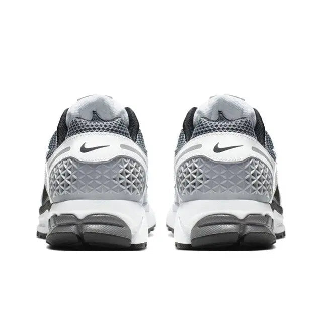 Back view of black, white and dark grey running sneakers with heel cushioning