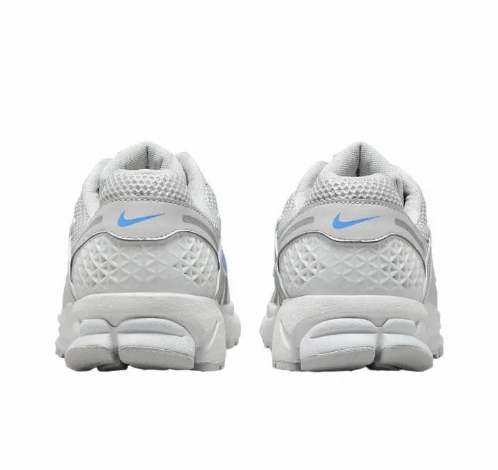 Running shoes heel view: white textured knit with blue swoosh on back, cushioned collar