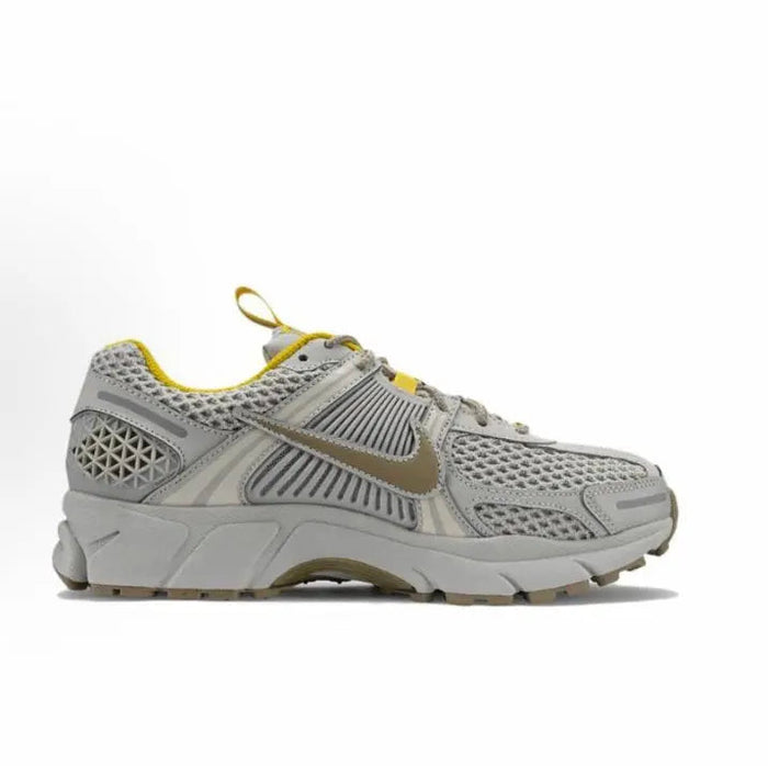 Light gray running sneaker with yellow collar, lace-up front, and mesh side panels