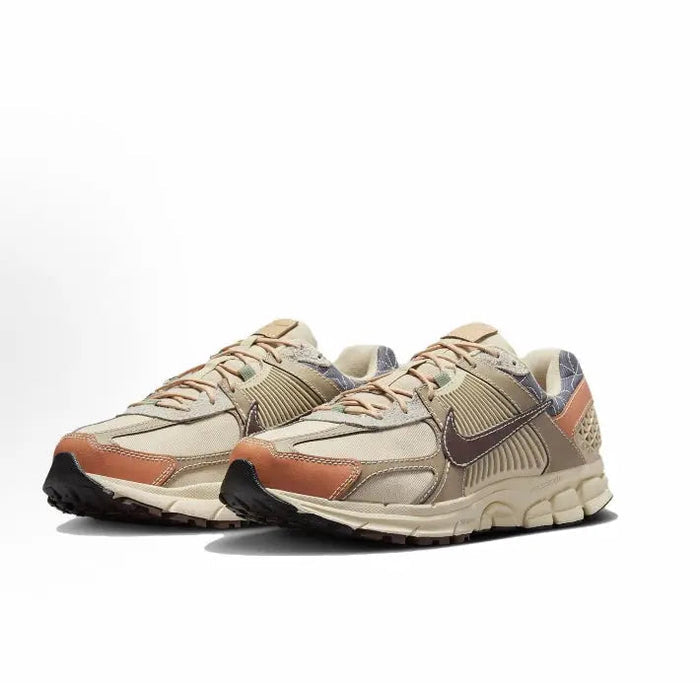 Nike Zoom Vomero 5 SP sneaker angled view in sand with rust panels and dark blue swoosh