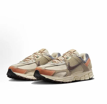 Nike Zoom Vomero 5 SP sneaker angled view in sand with rust panels and dark blue swoosh