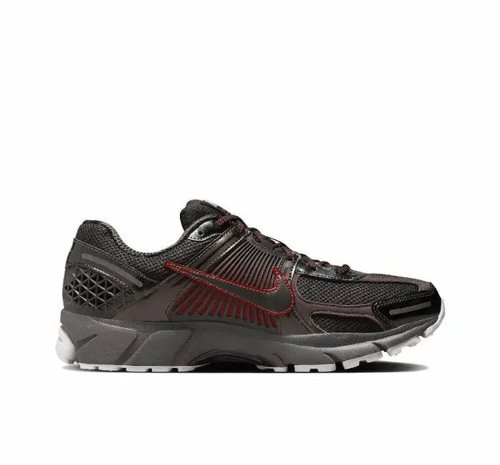 Running shoe side view, dark knit upper with red swoosh and white outsole