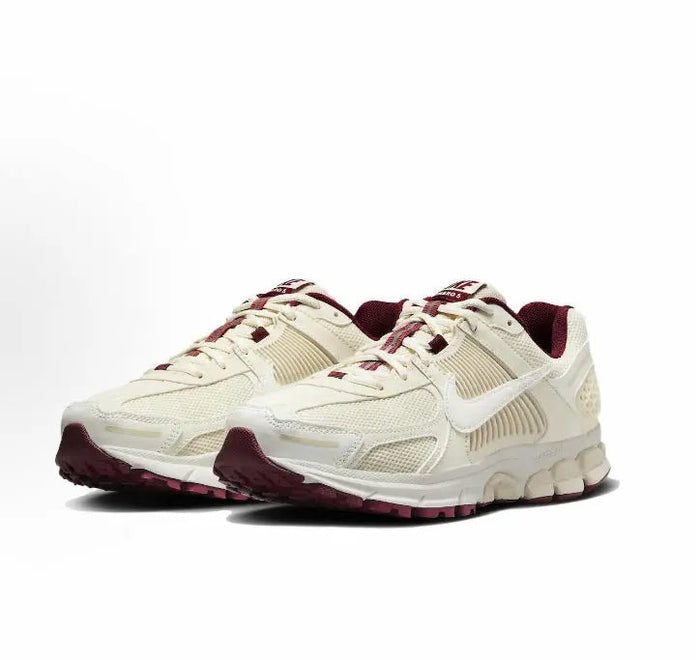 Front side view of white Nike running shoes with burgundy trim and laces