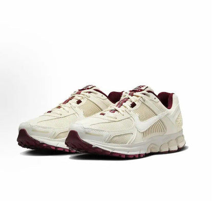 Front side view of white Nike running shoes with burgundy trim and laces