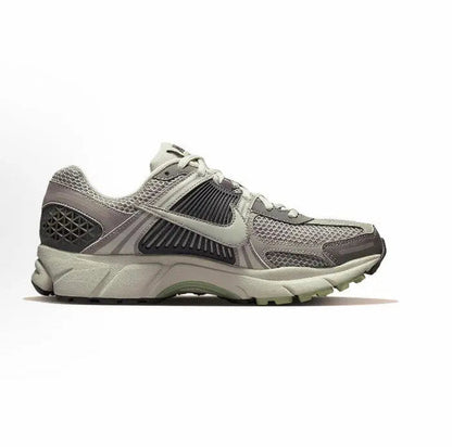 Running sneaker side profile, light gray mesh upper with dark midfoot stripes, lace-up