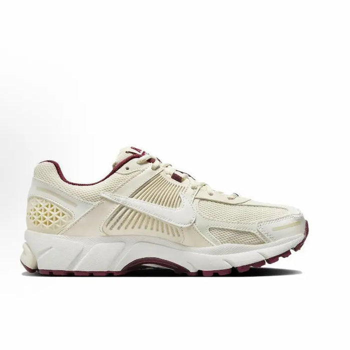 Side profile of white Nike running shoe with burgundy collar accents