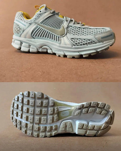 Light gray running sneaker side view and outsole tread with yellow accents