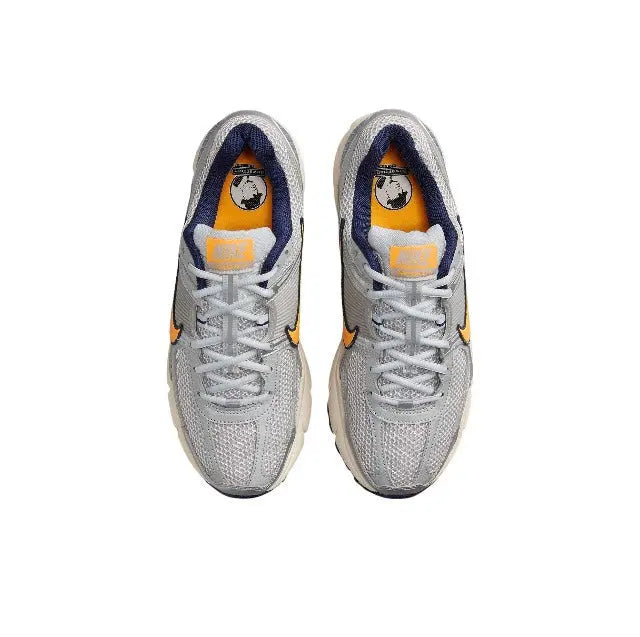 Nike running shoe top view, light gray mesh with orange accents and blue inner lining