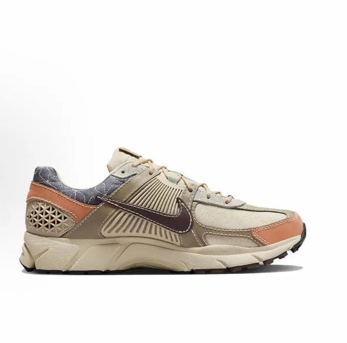 Nike Zoom Vomero 5 SP sneaker side view with sand mesh, rust heel, and dark blue collar