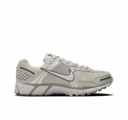 Nike Zoom Vomero 5 SP running shoe profile, light beige upper with black swoosh and blue sole