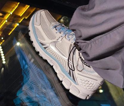 Running sneaker on foot, light grey upper with light-blue laces and chunky sole