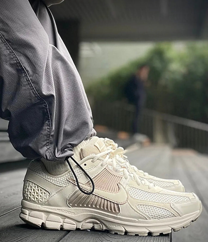 Pale ivory running sneaker with Nike Swoosh, mesh upper, and foam sole