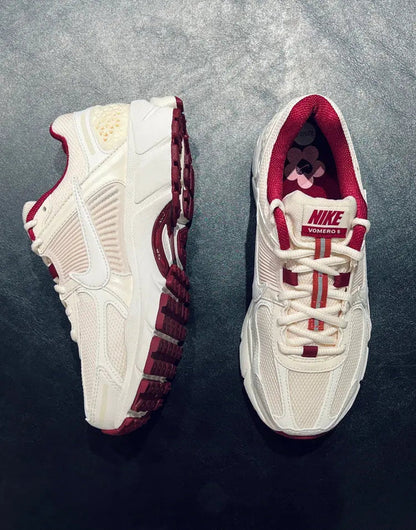 Close-up of white Nike sneakers with burgundy straps and flower detail