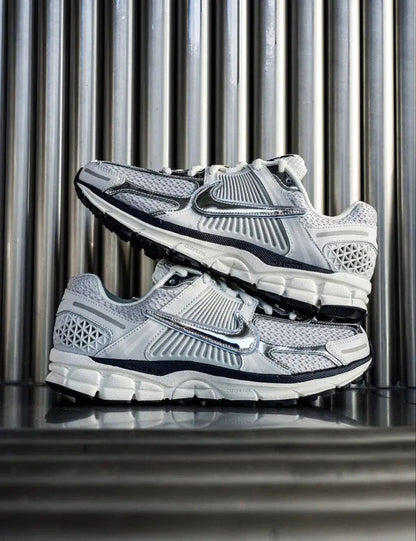Light gray running shoes shown in pair view with Nike swoosh and mesh heel